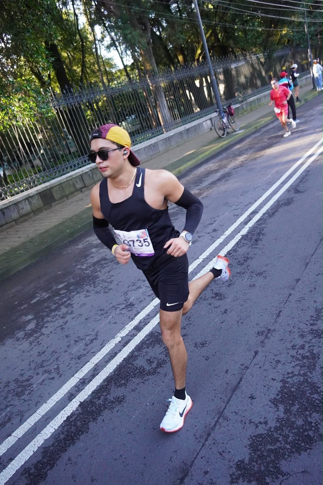Lalo corriendo un maratón en Ciudad de México, vestido de negro y con lentes de sol